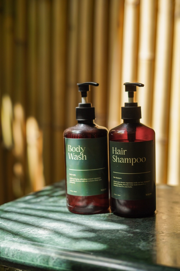 Amber body wash and shampoo bottles in dappled sunlight